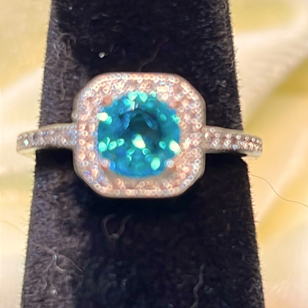 Silver ring with blue center stone and small white accent stones. S925. Size 7